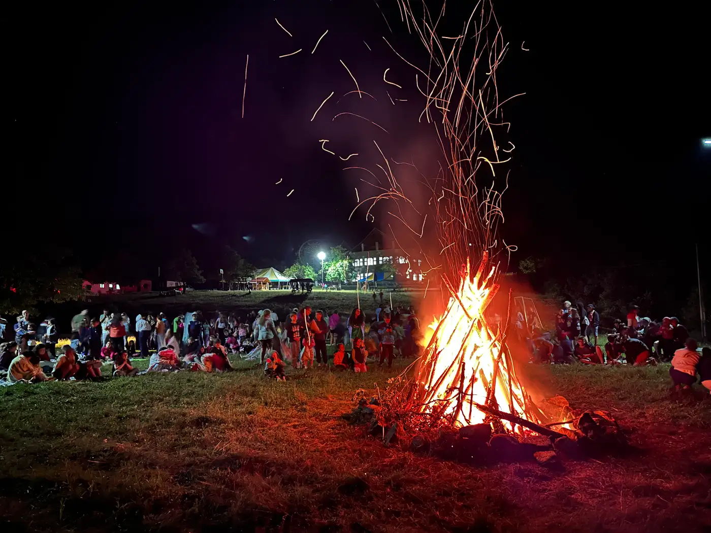 Campers gathered around an evening bonfire at the camp in Romania